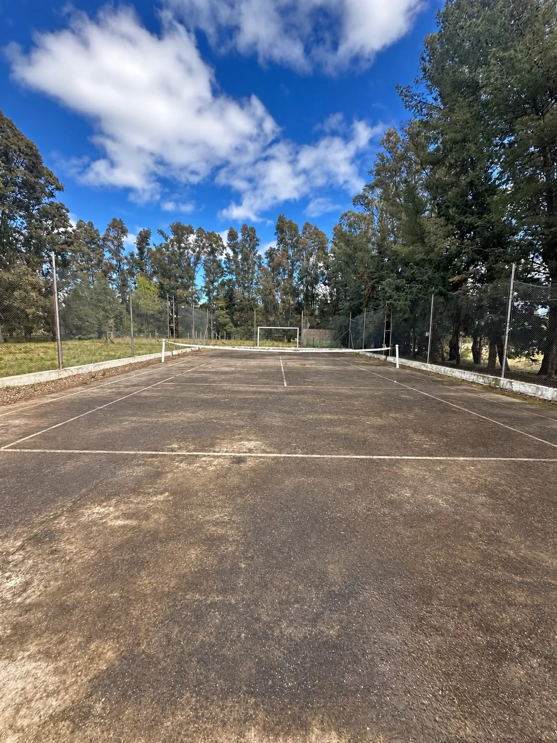 La cancha con red de tenis y arco de fútbol